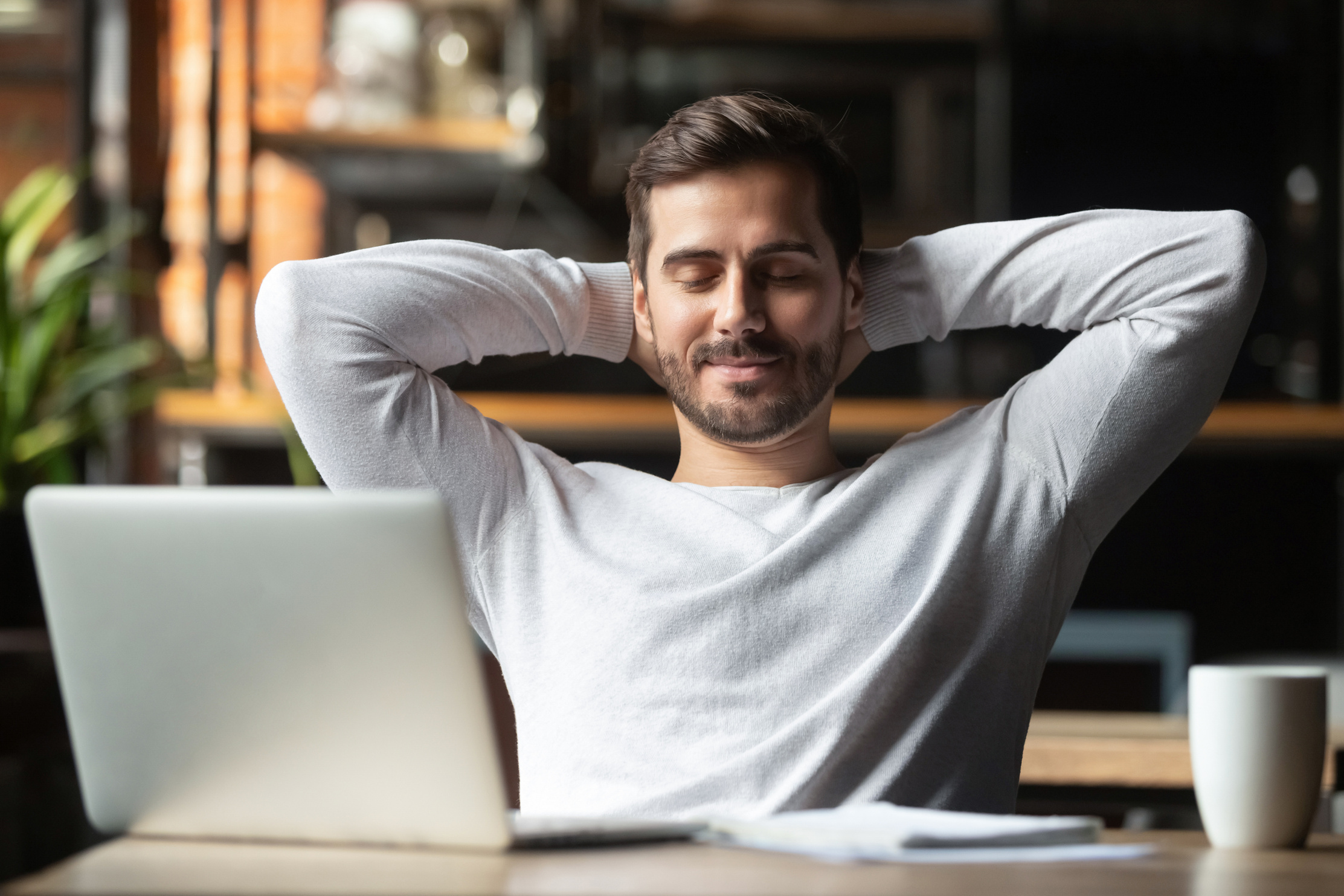 Relaxed happy businessman student worker lounge at desk meditating