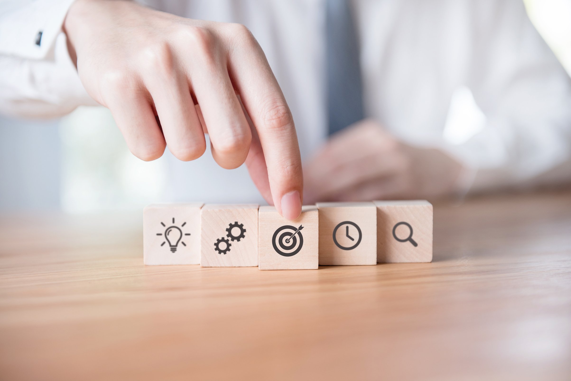 Businessman hand arranging wood block with icon business strategy and planning